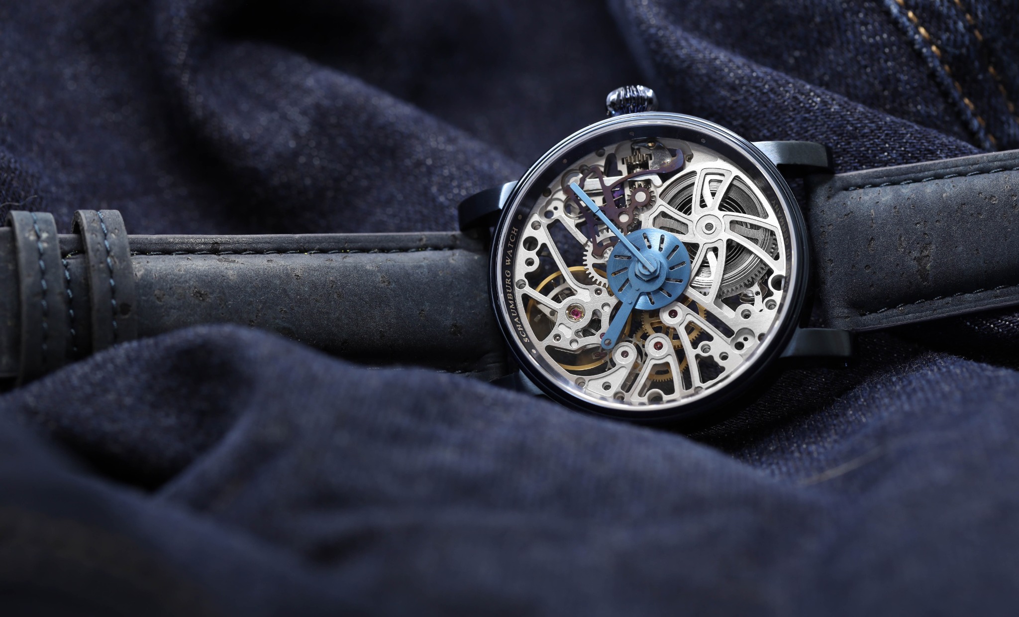 Craftsman II mit blauem Armband auf dunklem Textil