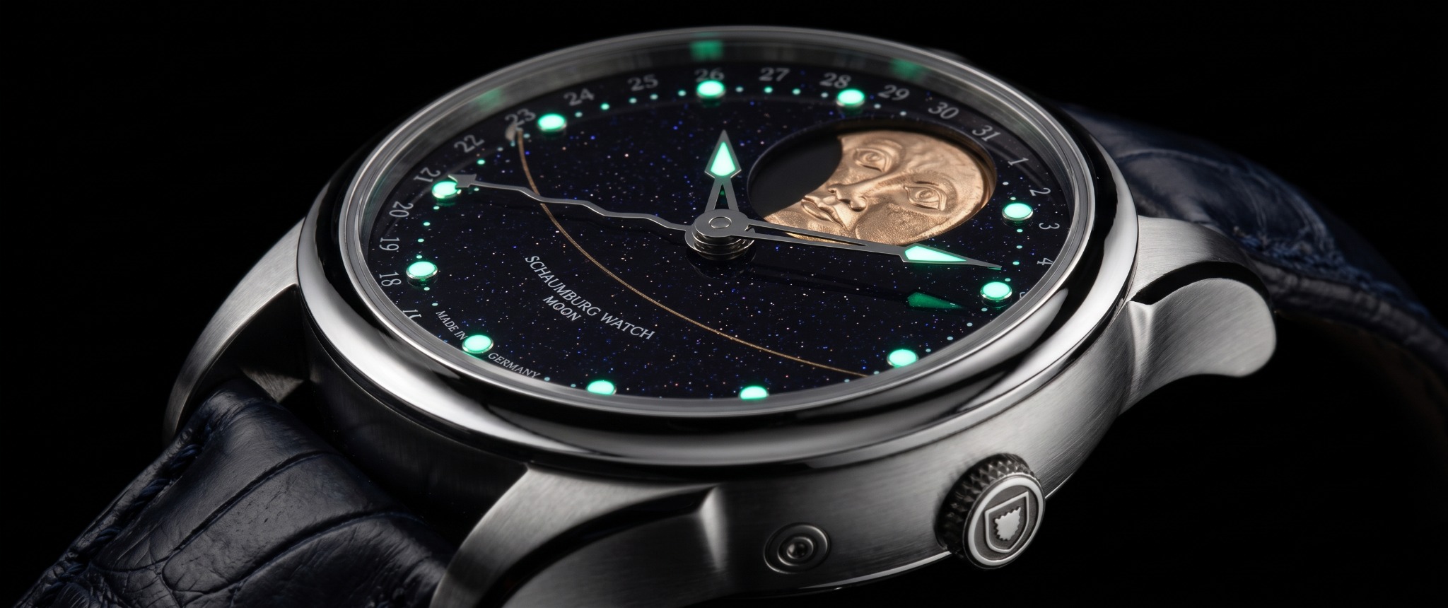 MooN Galaxy handmade von der Kronenseite mit blauem Aventurinzifferblatt, handgraviertem goldenem Mondgesicht und leuchtenden Zeigern und Indizes